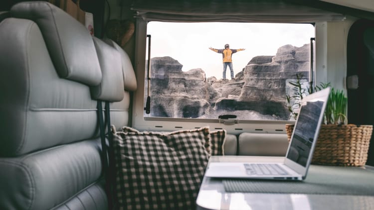 digital nomad standing outside his compact travel trailer similar to van life